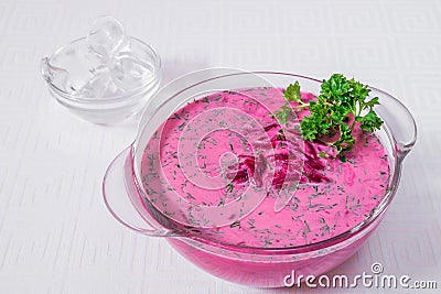 Delicious, appetizing pink soup with beets and herbs in a white plate. Horizontal frame Stock Photo