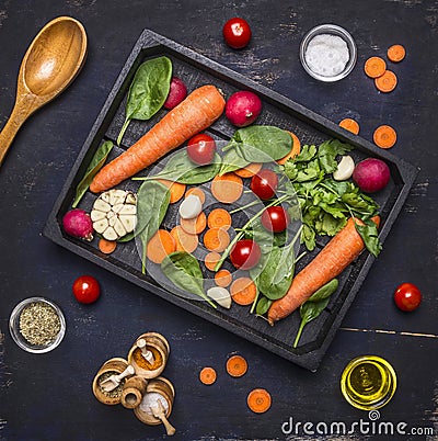 Delicious assortment of farm fresh vegetables sliced carrots, fresh spinach leaves, seasonings and butter, cherry tomatoes laid o Stock Photo