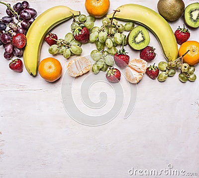 Delicious assortment of fresh fruit laid out in a border on a white rustic background top view Superfoods and health or detox die Stock Photo