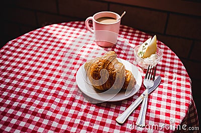 Delicious breakfast with fresh croissants and pears and cottage cheese on wooden board and red tablecloth background Stock Photo