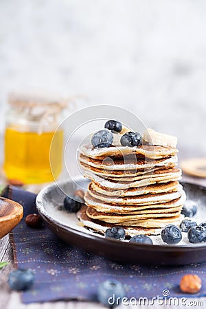 Delicious Breakfast pancakes on a plate with blueberries and honey Stock Photo