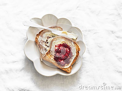 Delicious breakfast, snack - crispy toast with butter and cranberry jam on a light background, top view Stock Photo