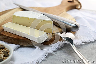 delicious brie cheese with cut slice on wooden plate with copy space Stock Photo
