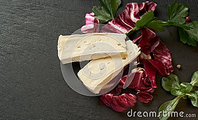 Delicious brie cheese with lavender on black background. Brie type of cheese. Camembert. Fresh Brie cheese and a slice on stone Stock Photo