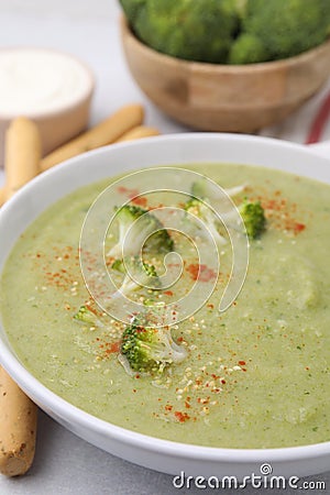 Delicious broccoli cream soup served on light table, closeup Stock Photo