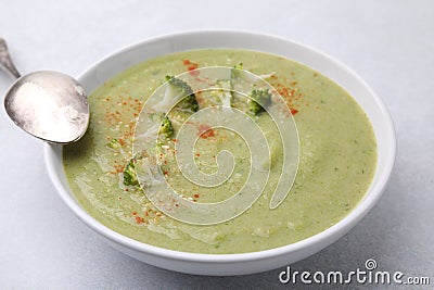 Delicious broccoli cream soup served on light table, closeup Stock Photo