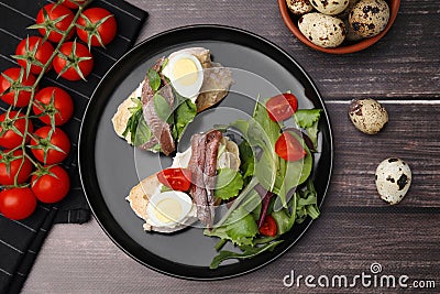Delicious bruschettas with anchovies, cream cheese, eggs and tomatoes on wooden table, flat lay Stock Photo