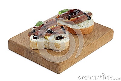 Delicious bruschettas with anchovies, eggs, basil and sauce on white background Stock Photo