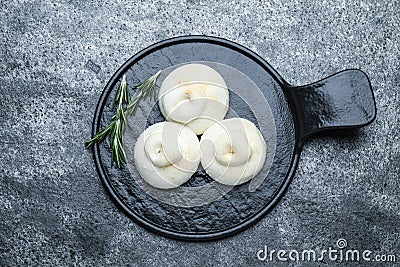 Delicious burrata cheese with rosemary on grey table, top view Stock Photo