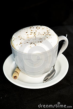 Delicious Cappuccino served with chocolate hazelnut wafer roll Stock Photo