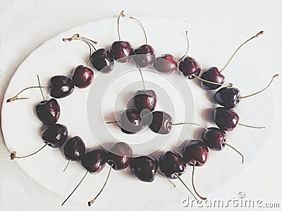 Delicious cherries form a circle in a white plate Stock Photo