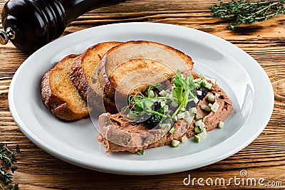 Delicious chicken, duck, or rabbit liver pate or foie gras with spices. fried toast and pate with microgreens Stock Photo