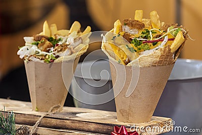 Delicious chicken and fries wrap street food with cheddar cheese sauce on the top, fast food buffet Stock Photo