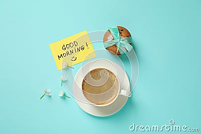 Delicious coffee, cookies, flowers and card with GOOD MORNING wish on blue background, flat lay Stock Photo