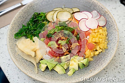 delicious colorful poke bowl with many ingredients at seafood restaurant during the day Stock Photo