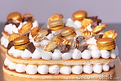 Delicious cream cake decorated with golden sweets. Stock Photo