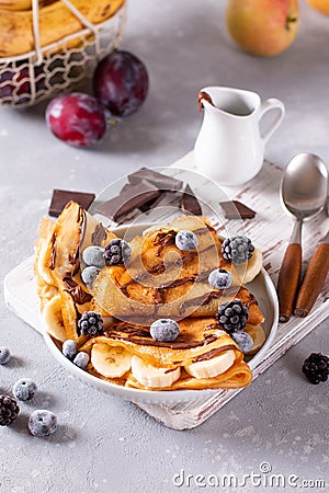 Delicious crepe with banana filling with chocolate sauce and berries Stock Photo