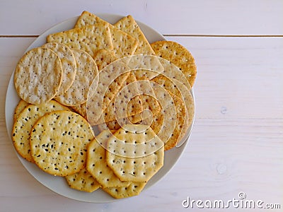 Delicious crisp salty crackers on plate on white background. Stock Photo