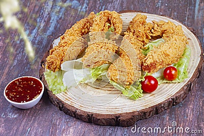 Delicious crispy fried breaded chicken breast strips with ketchup. Isolated on wooden background Stock Photo