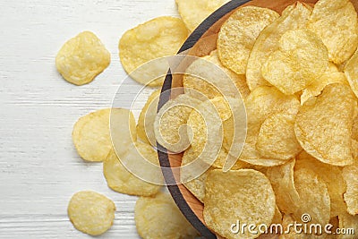 Delicious crispy potato chips in bowl on table, space for text Stock Photo