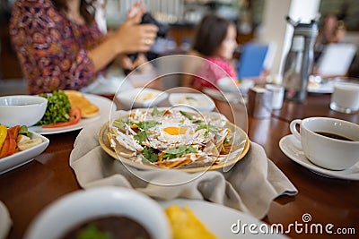 Delicious dishes and drinks on table with happy family as background Stock Photo