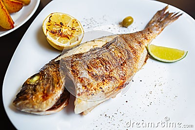 Delicious dorado fish cooked on grill with lemon,lime in Asian seafood restaurant.Gourmet mahi-mahi grilled for dinner in Asian Stock Photo