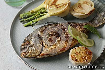 Delicious dorado fish with vegetables served on table, closeup Stock Photo