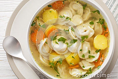 Soup with pelmeni dumplings a dish of Russian cuisine closeup on the bowl. Horizontal Stock Photo