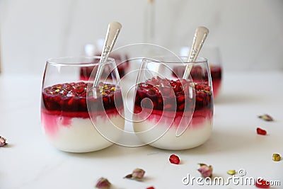 Delicious, festive Malabi: milk pudding dessert, popular in the Mediterranean, topped with pomegranate seed,Juice, pistachios & ro Stock Photo