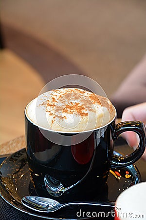 Delicious foamy cappuccino on a black cup Stock Photo