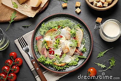 Delicious fresh Caesar salad on black table, flat lay Stock Photo