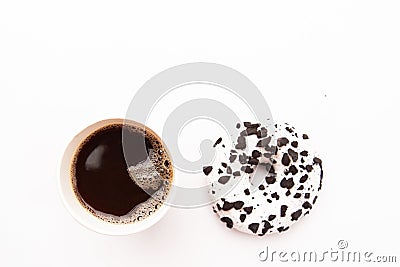 Delicious fresh donut black and white color with white icing and chocolate chips with paper glass of coffe closeup on a Stock Photo