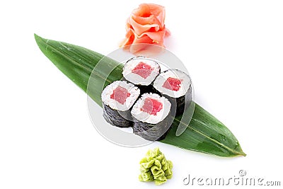 Delicious fresh mini-rolls with tuna on a banana leaf. Sushi rolls on a white background with ginger and wasabi. Stock Photo