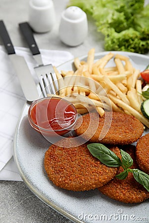 Delicious fried breaded cutlets with garnish on grey table, closeup Stock Photo
