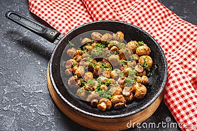 Delicious fried mushrooms in pan on stone table Stock Photo