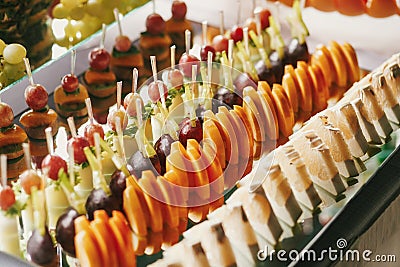Delicious fruits appetizers, desserts on stand, modern sweet table at wedding or baby shower. Luxury catering concept. Fruit bar Stock Photo