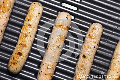 Delicious german sausages on the barbecue electro grill. Tasty sausages sizzling on a portable electric grilling on a summer Stock Photo