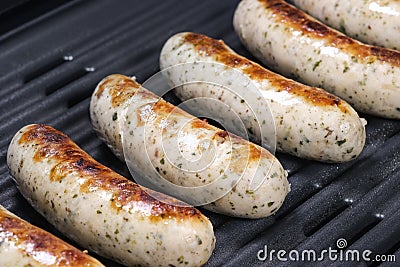 Delicious german sausages on the barbecue electro grill. Tasty sausages sizzling on a portable electric grilling on a summer Stock Photo