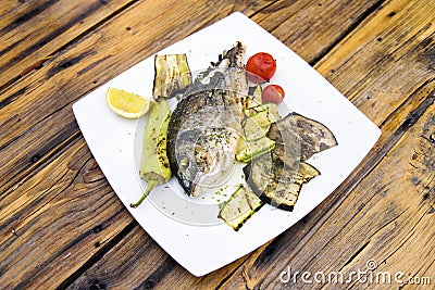 Delicious Grilled bream or dorade fish on wooden background Stock Photo