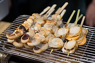 Grilled scallop and squid at Kuromon market Osaka Japan Stock Photo