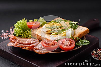 Delicious healthy lunch consisting of bacon, toast, eggs and tomatoes Stock Photo
