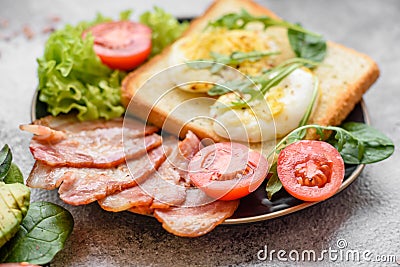 Delicious healthy lunch consisting of bacon, toast, eggs and tomatoes Stock Photo