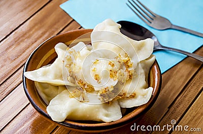 Delicious homemade dumplings in a plate on a wooden table. Stock Photo