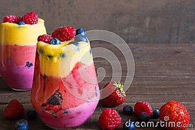 Delicious homemade layered fruit and berry smoothie dessert in glasses Stock Photo