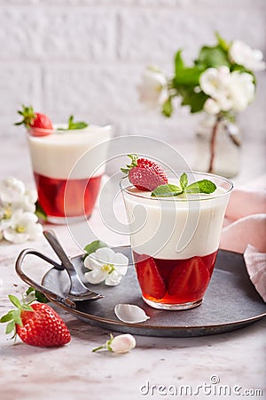 Layered dessert in glass with vanilla panna cotta and jelly with strawberries Stock Photo