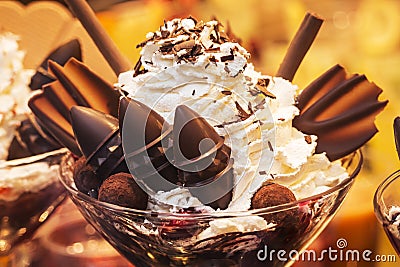 Delicious ice cream with fruits, chocolate, nuts in glass bowl. Close up Stock Photo