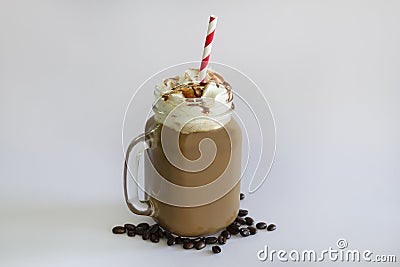 Delicious iced coffee or Frappuccino with whipped cream , syrup and a red straw . With Coffee beans isolated on white background Stock Photo