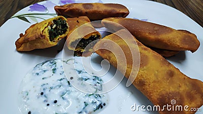 Delicious Indian snack called as kothimbir vadi seasoned with curd chutney. Stock Photo