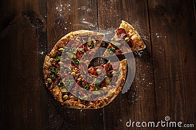 Delicious italian pizza with slice served on wooden table Stock Photo