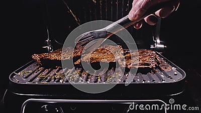 Delicious juicy meat steak cooking on grill. Aged prime rare roast grilling marble beef. Electric roaster, rosemary Stock Photo